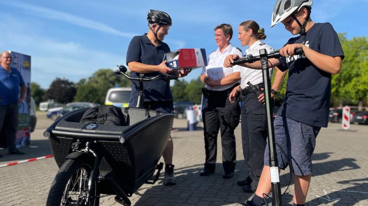 Nach der Runde mit dem Lastenrad: Steffen de Vries nimmt einen neuen Fahrradhelm von Christiane Oewerdieck und Stefanie Wasmundt (r.) entgegen. Vorn Lenny Pedersen mit E-Roller.