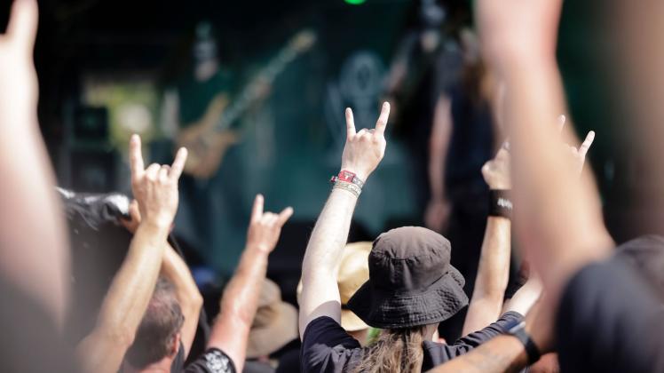 «Pommesgabeln»: Metal-Fans tanzen während eines Auftritts der Band Mythraeum aus den USA vor der Bühne. Foto: Frank Molter/dpa