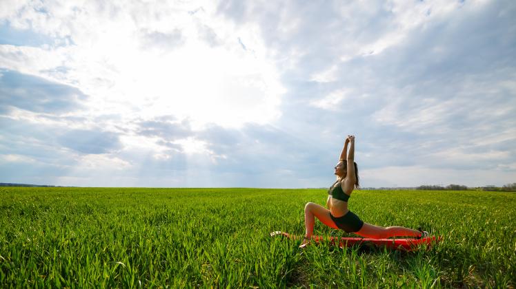 Young athletic woman doing stretching yoga exercises outdoors. Ukrainka, Kyiv Oblast, Ukraine CR_DMDM220713-1010615-01 ,