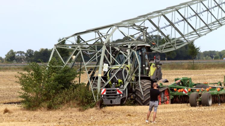 Landwirt fährt mit Traktor Mast um
