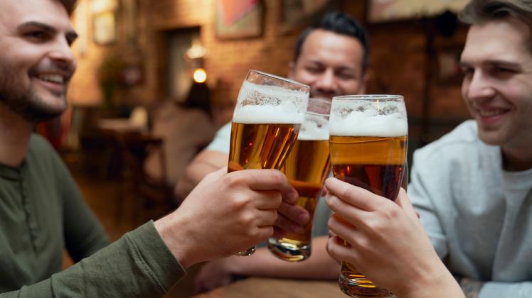 Friends meeting in a pub and clinking beer glasses model released, Symbolfoto property released, ABIF01688