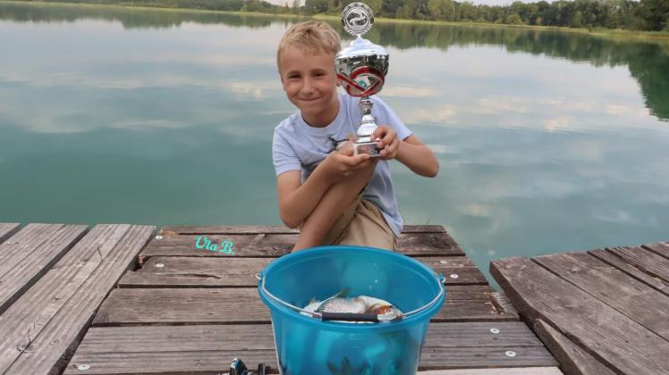 Maximilian Zajak aus Plön war beim Gästefischen des Plöner Sportfischervereins einer der jüngsten und zugleich der erfolgreichste Angler. Für den Fang eines Eimers voller Plötzen freute er sich über einen kleinen Pokal.