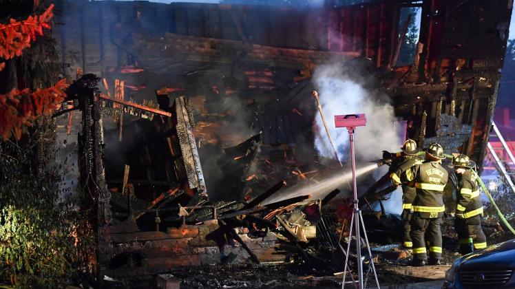 Feuerwehrleute an der Brandruine des Hauses, das während eines tödlichen Brandes einstürzte. Foto: Jimmy May/Bloomsburg Press Enterprise/dpa