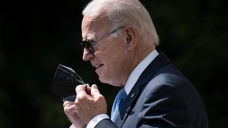 (FILES) In this file photo taken on July 27, 2022, US President Joe Biden removes his protective mask while arriving to deliver remarks in the Rose Garden of the White House in Washington, DC. - US President Joe Biden on August 6, 2022, tested negative for Covid-19, days after coming down with a second bout of the illness. (Photo by Brendan Smialowski / AFP)