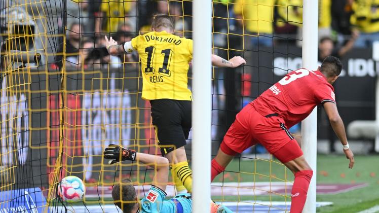 dpatopbilder - Dortmunds Marco Reus (M) stochert den Ball gegen Leverkusens Torwart Lukas Hradecky (l) und Piero Hincapie über die Linie. Foto: Bernd Thissen/dpa