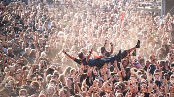 dpatopbilder - Festivalbesucher werden beim Wacken Open Air Festival beim Crowdsurfen über die Menge getragen. Foto: Daniel Reinhardt/dpa/Archivbild