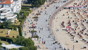 ARCHIV - Teilnehmer des Holstentorturniers und Spaziergänger sind auf der Strandpromenade zu sehen. Foto: Georg Wendt/dpa