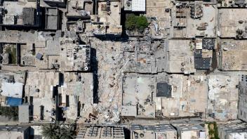 Palästinenser durchsuchen die Trümmer eines Gebäudes, in dem Khaled Mansour, ein führender Kämpfer des Islamischen Dschihad, am 07.08.22 bei einem israelischen Luftangriff getötet wurde. Foto: Hatem Moussa/AP/dpa