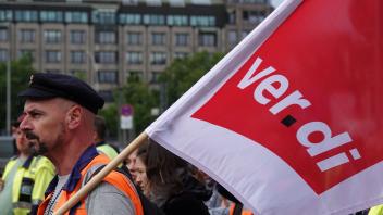 ARCHIV - Hafen-Beschäftigte mit Verdi-Fahnen bei einem Protestzug im Mitte Juli in Hamburg. Foto: Julian Weber/dpa