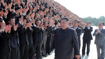 HANDOUT - Nordkoreas Machthaber Kim Jong Un grüßt Gesundheitsbeamte und Wissenschaftler während eines Fototermins in Pjöngjang. Foto: -/KCNA/KNS/dpa - ACHTUNG: Nur zur redaktionellen Verwendung und nur mit vollständiger Nennung des vorstehenden Credits