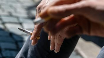ARCHIV - Zwei Raucher halten ihre Zigaretten zwischen den Fingern. Foto: Armin Weigel/dpa