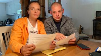 Tanya Opanashchenko und Ivan Apoliarov lesen die Dokumente, die sie von der Ausländerbehörde in Lübeck geschickt bekommen haben.