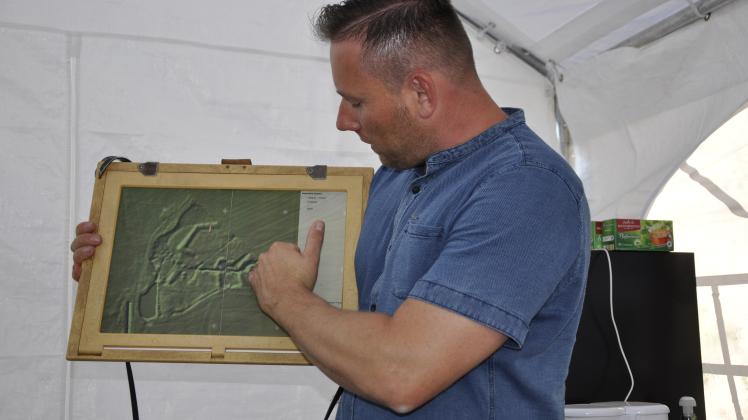 Gordon Thalmann zeigt den Gästen auf einer digitalen Karte, wo sich die mittelalterliche Motte befindet.