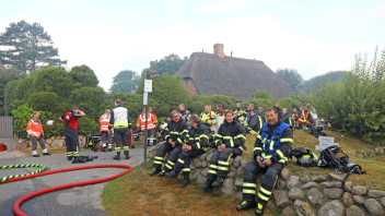 Am Mittwochmorgen auf Sylt: Feuerwehrleute pausieren nach dem stundenlangen Einsatz in der Nacht.