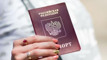 ARCHIV - Eine Russin zeigt ihren Reisepass. Estland hat als eine Reaktion auf Russlands Angriffskrieg die Vergabe von Visa und Aufenthaltsgenehmigungen an Russen ausgesetzt. Foto: picture alliance / dpa