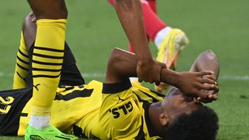 Fällt für Dortmund aus: Karim Adeyemi liegt beim Spiel gegen Leverkusen verletzt auf dem Rasen. Foto: Bernd Thissen/dpa