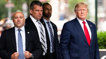 Donald Trump (r) und Sicherheitsleute in New York. Der ehemalige US-Präsident spricht im Zusammenhang mit Ermittlungen gegen ihn immer wieder von einer Hexenjagd. Foto: Julia Nikhinson/AP/dpa
