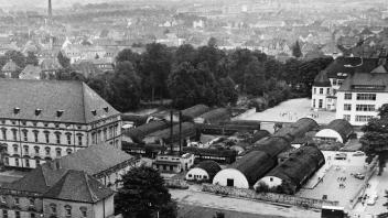 Blick vom Katharinenkirchturm auf die britischen Nissenhütten im Schlossgarten in den 1950er-Jahren. Links das Schloss, rechts das Ratsgymnasium. 