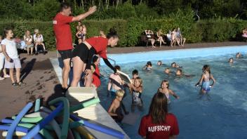 Schwimmeister Thomas Kührmann weist die Ferienkinder am vergangenen Donnerstagabend zur Abschluss-Show für das Ablegen des Schwimmabzeichens ein.