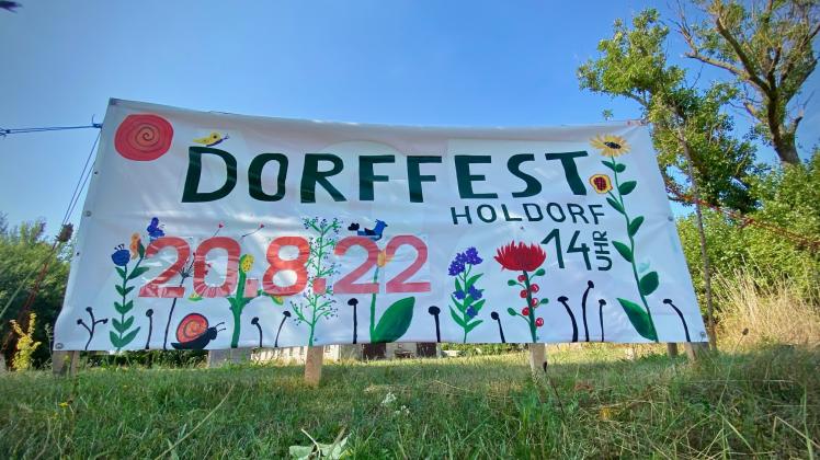 Auf bunten Plakaten kündigt die Gemeinde Holdorf das Dorffest an.