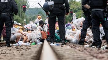 Klimaaktivisten haben Bahngleise der Hamburger Hafenbehörde besetzt. Foto: Markus Scholz/dpa