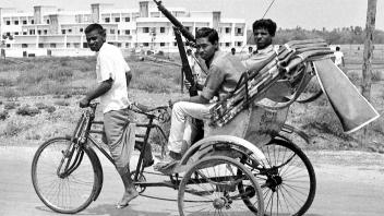 ARCHIV - Bewaffnete ostpakistanische Kämpfer fahren 1971 in Jessore, damals in Ostpakistan, in einem Fahrradtaxi zur Kampffront. Die Stadt nahe der Grenze zu Indien war Schauplatz heftiger Kämpfe zwischen ostpakistanischen Anhängern des bengalischen Nationalistenführers Sheikh Mujibur Rahman und pakistanischen Streitkräften. Foto: Uncredited/AP/dpa