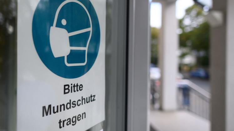 ARCHIV - Ein Schild weist an der Tür eines Krankenhauses in Dresden auf die Maskenpflicht hin. Foto: Robert Michael/dpa-Zentralbild/dpa