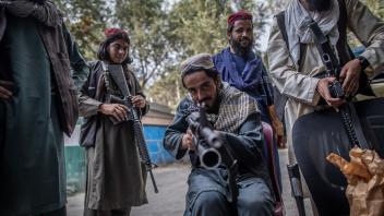 ARCHIV - Ein junger Taliban-Kämpfer zielt zum Spaß mit seinem Gewehr in Richtung Fotograf, während er vor einer Polizeistation in Kabul Wache hält. Foto: Oliver Weiken/dpa