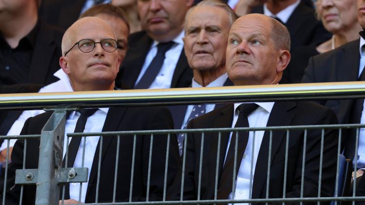 German Chancellor Olaf Scholz (R) and Hamburg’s First Mayor Peter Tschentscher (L) attend in the Volkspark stadium the funeral service for former German football player Uwe Seeler in Hamburg, northern Germany, on August 10, 2022. - German former football player Uwe Seeler has died aged 85, on July 21, 2022. (Photo by Christian Charisius / POOL / AFP)