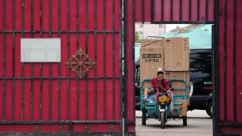 Ein Zusteller transportiert Haushaltsgeräte von einem Auslieferungszentrum. Foto: Ng Han Guan/AP/dpa