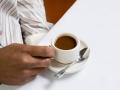 African American male hand holding handle of expresso cup. PUBLICATIONxINxGERxSUIxAUTxONLY Copyright: RonxChapplexStock