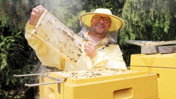 Pastor Jonas Görlich schaut, ob es dem Bienenvolk gut geht.