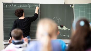 ARCHIV - Eine Lehrerin schreibt in einer Schule an die Tafel. Foto: Sebastian Gollnow/dpa/Symbolbild