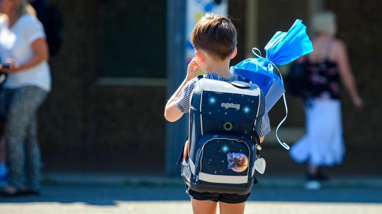 Beginn des Schuljahres 2022/23 Beginn des Schuljahres 2022/23 Ein Kind steht mit blauer Schultüte und Schultüte auf dem