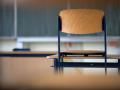 ARCHIV - Ein Stuhl steht in einem Klassenzimmer auf dem Tisch. Foto: Marijan Murat/dpa/Symbolbild