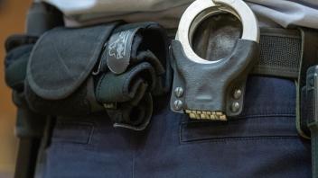 ARCHIV - Handschellen stecken in der Gürtelhalterung eines Justizbeamten. Foto: Friso Gentsch/dpa/Symbolbild