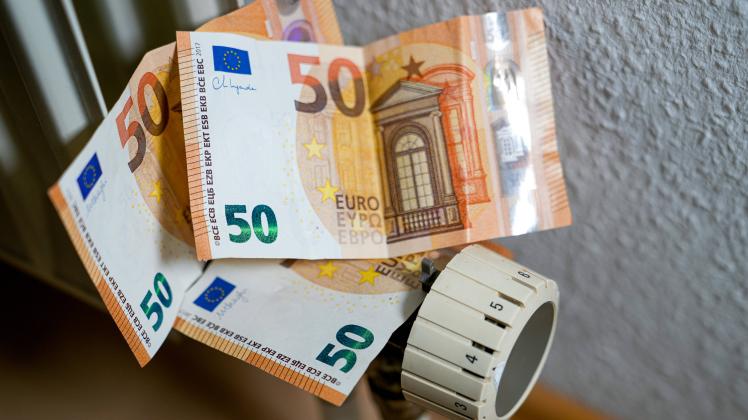 Das Bild zeigt Euroscheine (50 Euro Scheine) auf einem Temperaturregler an einer Heizung, die trotz der steigenden Energ
