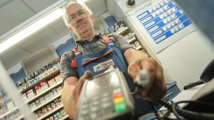 Seit drei Monaten vom bargeldlosen Zahlungsverkehr abgeschnitten – wegen eines fehlenden Kabels: Rolf Clausen mit dem Kartenterminal in seiner Tankstelle