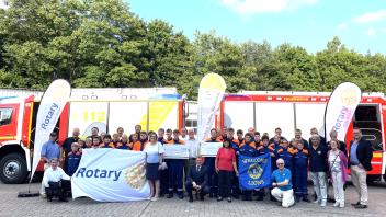 Mitglieder des Rotary Clubs Wedel, des Lions Club Elbmarsch und Mitglieder der Jugendfeuerwehren in Wedel und Holm während der Scheckübergabe.