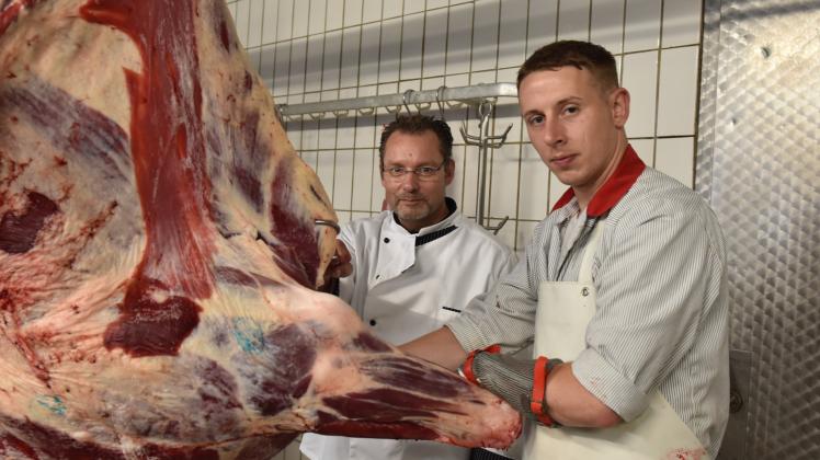 Michael Schmidt (r.), Inhaber der Fleischerei Schmidt in Rhede, stabilisiert die Rinderhälfte für seinen Fleischergesellen Dennis Nagel (l.).
