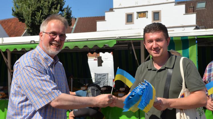 Roman Kaznovetskyi (rechts), Bürgermeister von Lingens ukrainischer Partnerstadt Lanivtsi, verteilte zum ukrainischen Unabhängigkeitstag am 24. August auf dem Lingener Wochenmarkt Fähnchen. Auch Christoph Böckmann erhielt eines. 