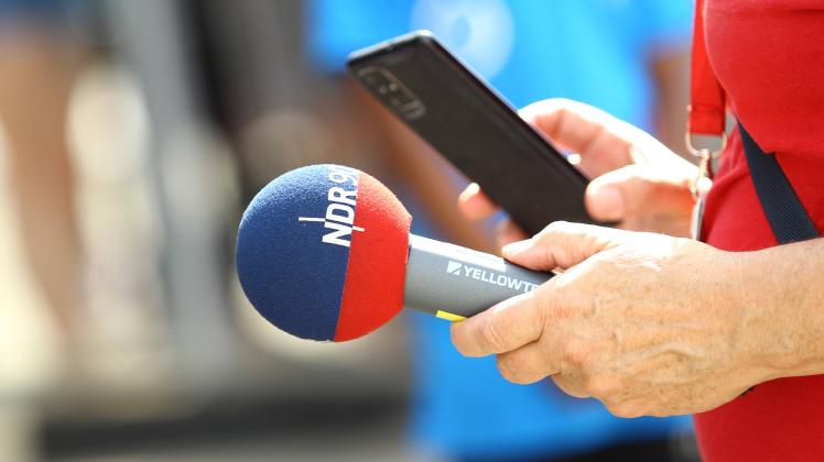 Ein Reporter des Radiosenders NDR 90,3 hält ein Mikrofon mit dem Schriftzug des Radiosenders in der Hand. Neustadt Hambu