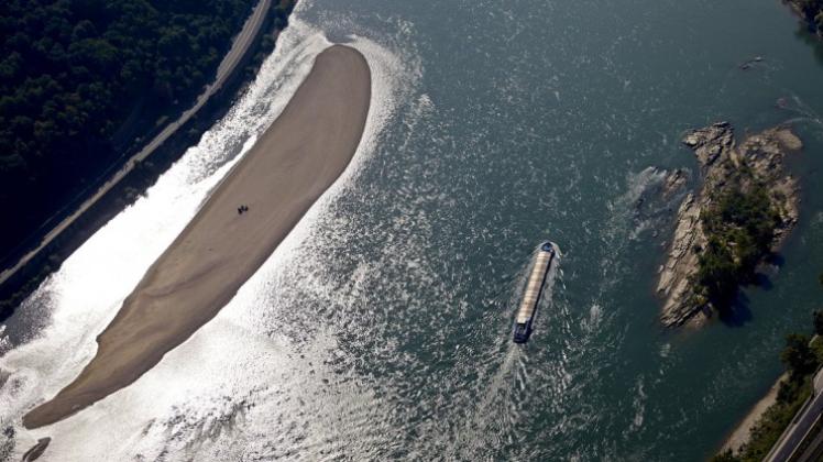 Die Luftaufnahme zeigt ein Frachtschiff, das auf dem Rhein bei Oberwesel inRheinland-Pfalz an einer Sandbank vorbeifährt. Der Rhein führt zur Zeit Niedrigwasser. 