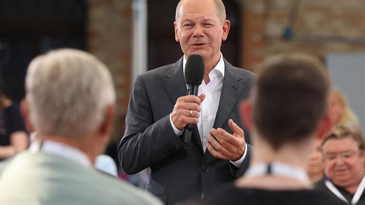 German Chancellor Olaf Scholz talks with participants of a so-called "citizens dialogue" event on August 25, 2022 in Magdeburg, eastern Germany. (Photo by Ronny HARTMANN / AFP)