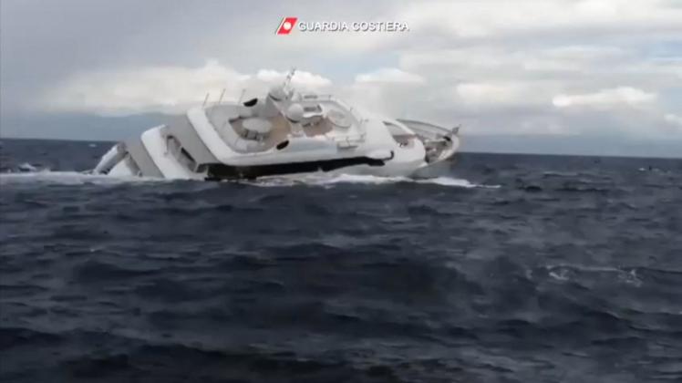 This handout grab video taken and released by Guardia Costiera on August 23, 2022 shows a luxury yacht sinks some 15 km off the coast of Catanzaro, in southern Italy. - All four passengers and five crew members were rescued from the 40-metre vessel, which was heading from Gallipoli to Milazzo when it sank. The reason the yacht sank is unclear and an investigation has been opened. (Photo by GUARDIA COSTIERA / AFP)