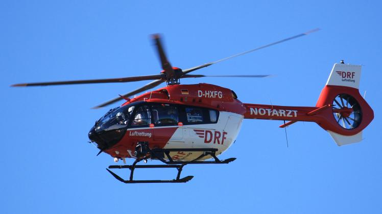 Ein CHX42 D-HXFG Hubschrauber fliegt am blauen Himmel.