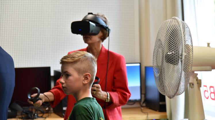 Linus vom Gymnasium an der Willmsstrae zeigt im Makers Space der Bundesbildungsministerin Bettina Stark-Watzinger den Umgang mit der VR-Brille. 