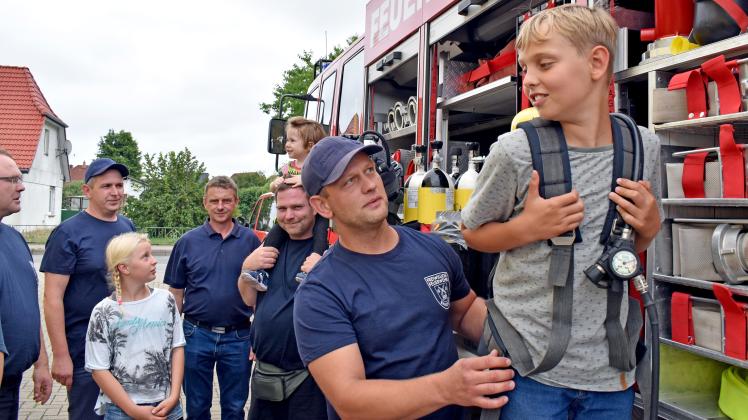 Wie schwer ist eigentlich so einem Feuerwehrausrüstung? Brandschützer Roy Hanske zeigte dem kleinen Bosse, wie schwer so eine Druckluftflasche ist.