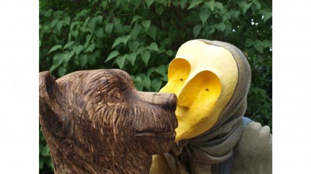 Gelbe Maske küsst Holzbären, auch ein Stück Kunst zwischen den alten Höfen Suttorfs.