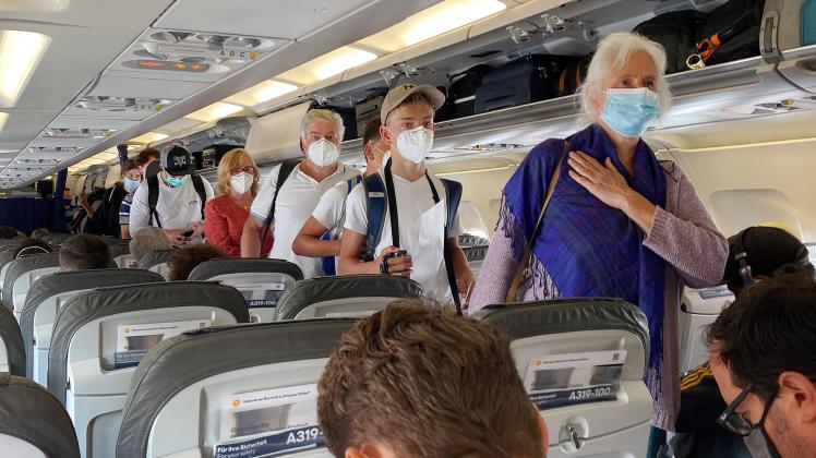 Fliegen in Zeiten der Coronavirus Pandemie, Boarding,Passgiere beim Einsteigen mit in eine Lufthansa Maschine Mundschutz